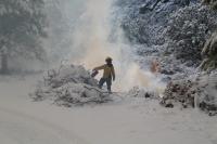 Firefighter ignites burn pile.