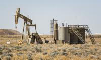 Picture shows a pump jack in the sage brush covered high desert of Utah