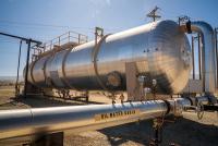 A large silver tank with pipes coming in and out of it. 
