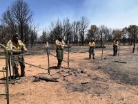 Wildland firefighters and other staff complete fence repair