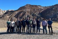 A line of DAC members stands in front of rocky, white desert hills.