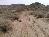 A dirt road into desert hills