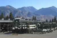 A geothermal plant in front of large mountains. 