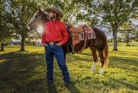 Man standing with his horse. 