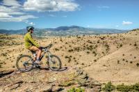 The San Luis Valley lays out in front of a mountain biker as he peers down from an elevated position.