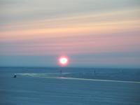 Ice road in northeast National Petroleum Reserve in Alaska with sun very low on the horizon.
