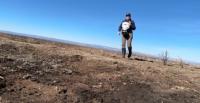 A BLM wildlife biologist uses a seed spreader to broadcast seeds.