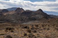 A landscape photograph shows Rhyolite Ridge against a cloudy sky.