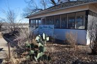 A house with desert plants outside. A sign reads San Pedro House.