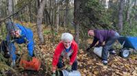 National Public Lands volunteers gathering leaves and dirt under trees