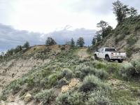 Law enforcement vehicle on a dirt road with mountain landscape 