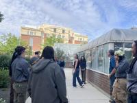 Image of students on campus in front of greenhouse