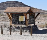 A kiosk with a hill in the desert background.