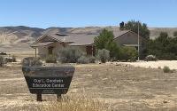 A visitors' center in a dry grassland with hills in the background