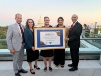 Left to right standing on roof to in Washington, D.C: Lanny Erdos, Tina Roberts-Ashby, two representatives from the Alaska Resource Education holding their framed award, and Stevan Pearce.