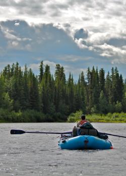 River rafter entering the headwaters of the Gulkana River during the summer.