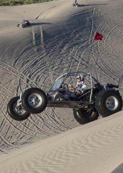 Dune buggy doing a wheely in the sand dunes