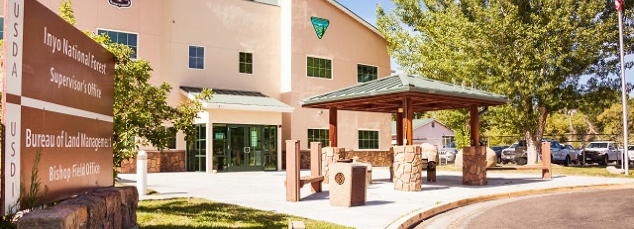 Bishop Field Office: a large white building with green trees. (Jesse Pluim/BLM)