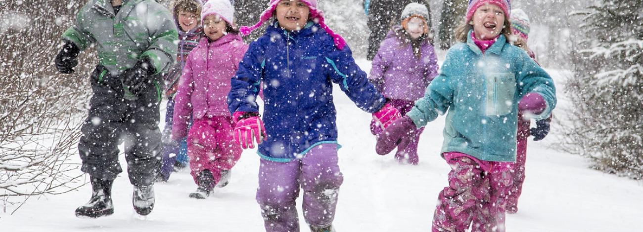 Excited children run through the snow down the trail during a program at the Campbell Creek Science Center.