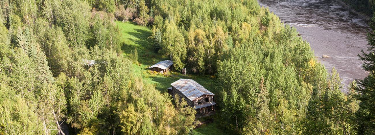 Steele Creek Community aerial view showing 3 wood structures along the Fortymile River