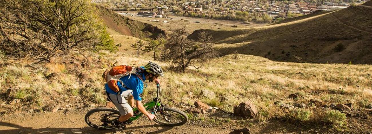 mountain biker with town of salida in background