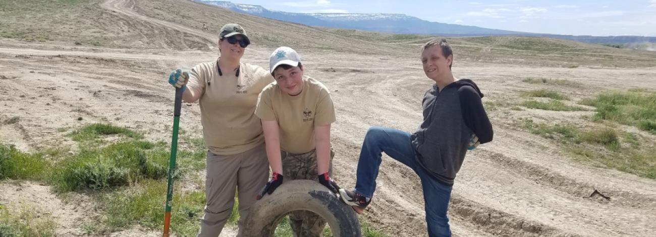 Volunteers stand with tires collected during volunteer cleanup project
