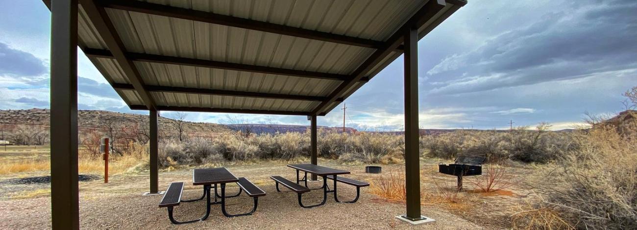 Westwater Group Site picnic tables underneath shade shelter.