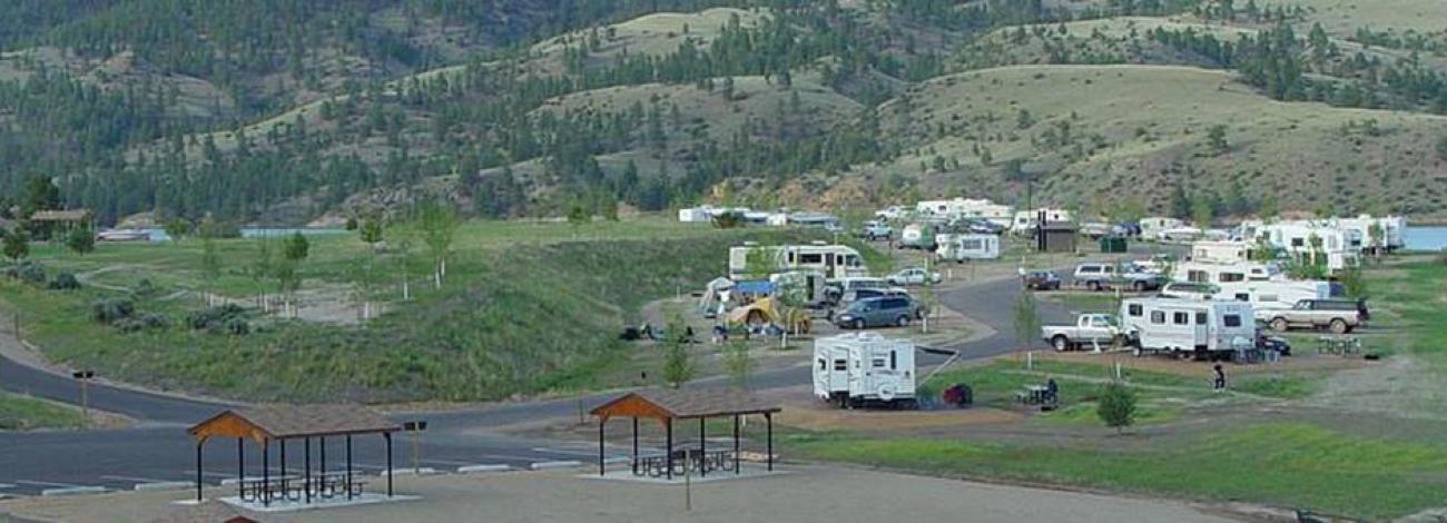 BLM White Sandy Campground overview. Beach area in the foreground. Site located on Hauser Lake. Campsites located along water's edge.