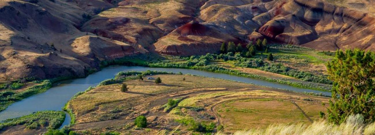 The John Day River winding through red and yellow clay hills 