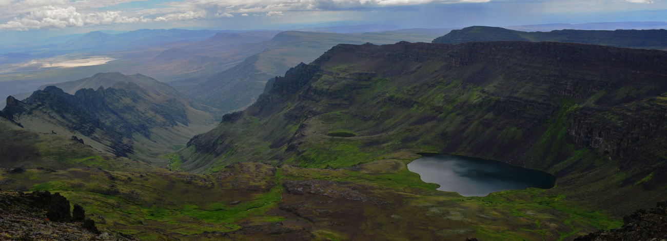 Steens Wilderness showing landscape of Mountains, trees, and alpine lake