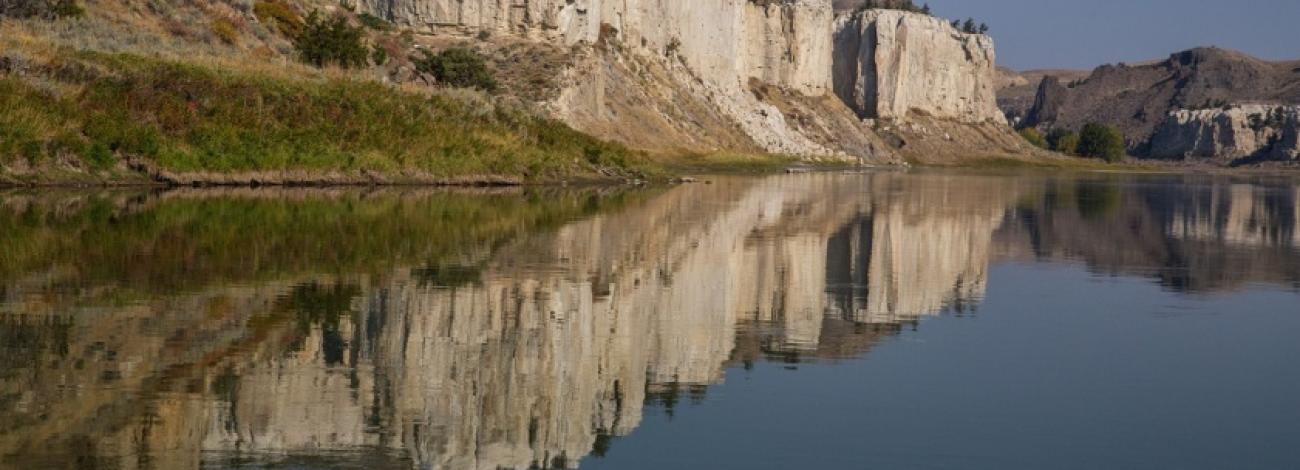 The majestic cliffs of Upper Missouri Breaks National Monuments reflected in the Missouri River. Photo by Bob Wick.