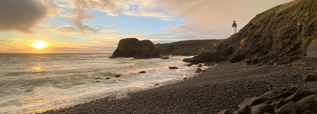 Yaquina Head Outstanding Natural Area showing Pacific Ocean on Cobble Beach and orange sunset on the horizo