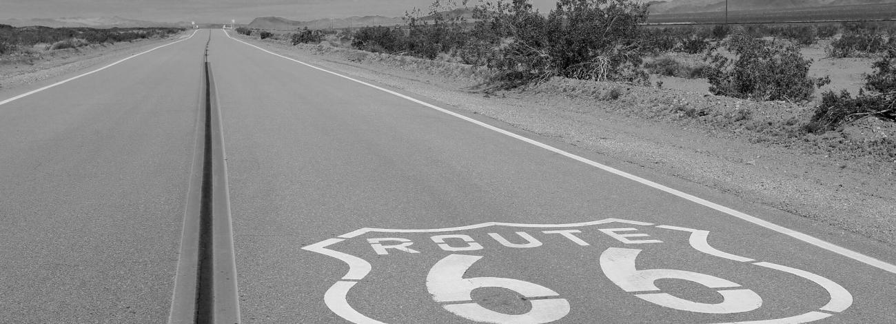 Route 66 painted on stretch of highway in the desert.