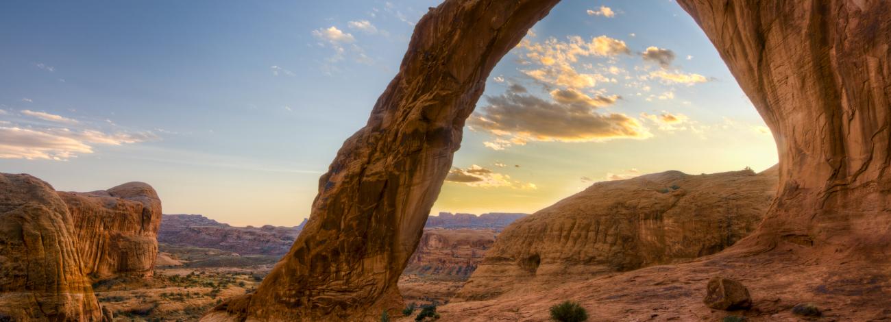 A rock arch framing a cloud