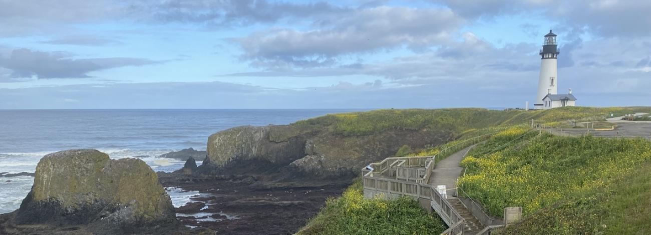 photo of a lighthouse on a cliff above the ocean