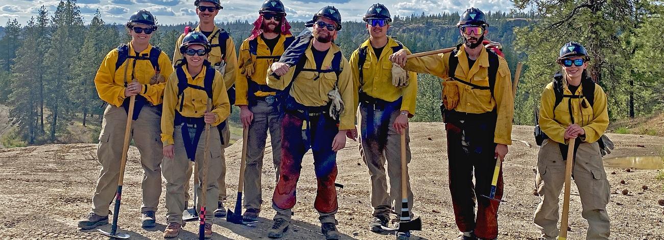 firefighters in a woodland area standing in a row