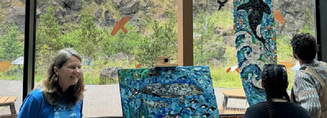 Artist in residence Rena Ekmanis shows off her work to visitors at the Yaquina Head Interpretive Center
