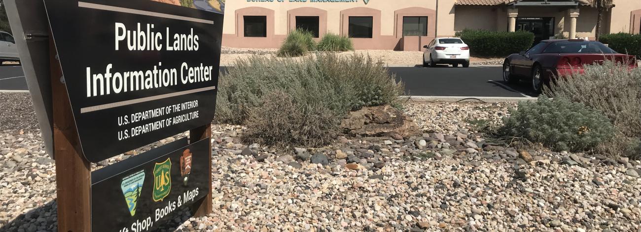 Sign that says Public Lands Information Center with a building in the background that has the words Bureau of Land Management on it