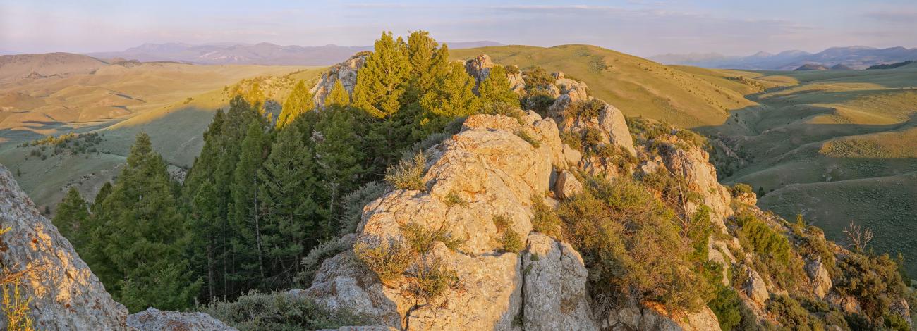 Rocky outcropped over hand looking into a distant landscape of rolling hills