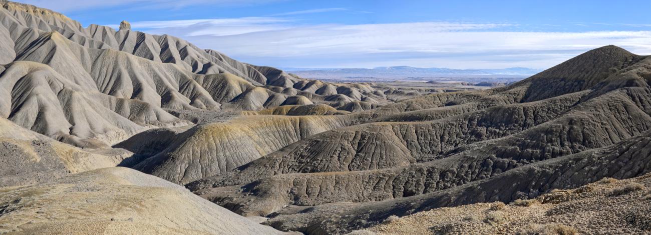 Rolling gray hills barren and little vegetation. 