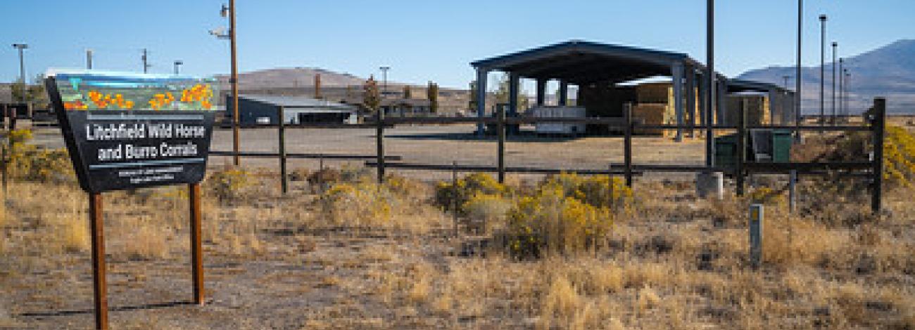 A sign reading Litchfield corral and a large  covered  structure with hay underneath.