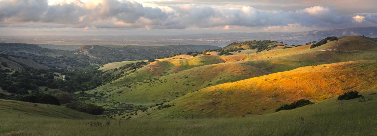 Sunset over rolling grass hills