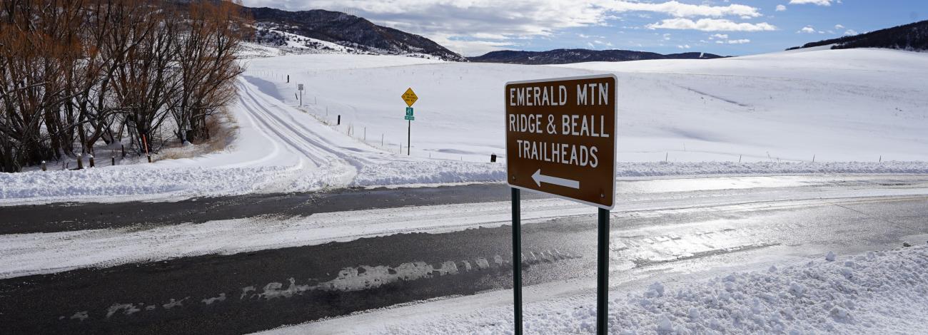 roadside sign along roads covered in snow