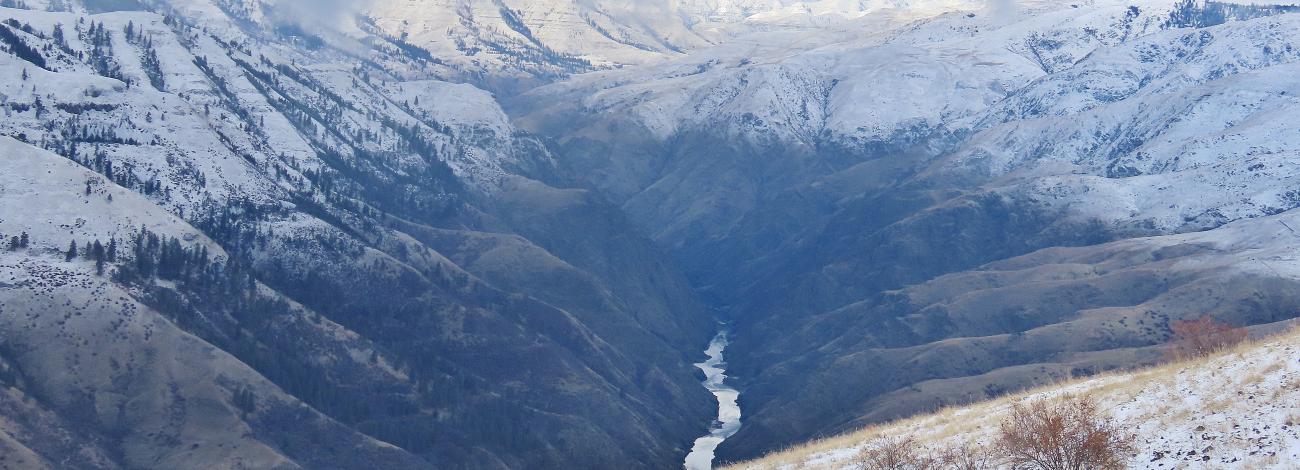 Photo shows a river canyon with snow covered mountain tops framing the river. Located in the Cottonwood Field Office.