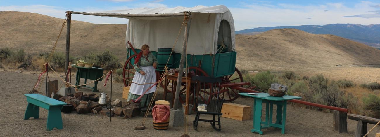 Oregon Trail wagon encampment with re-enactors showing the pioneer experience