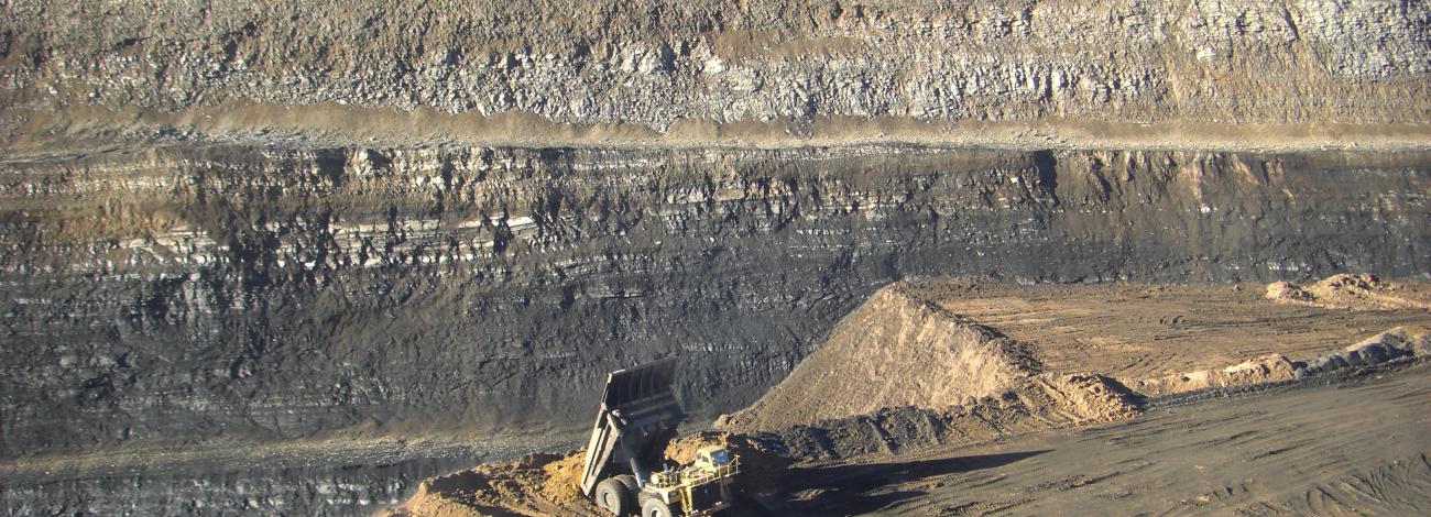 Bulldozer at edge of Dry Valley Mine gorge.  Gorge is striated in color. 