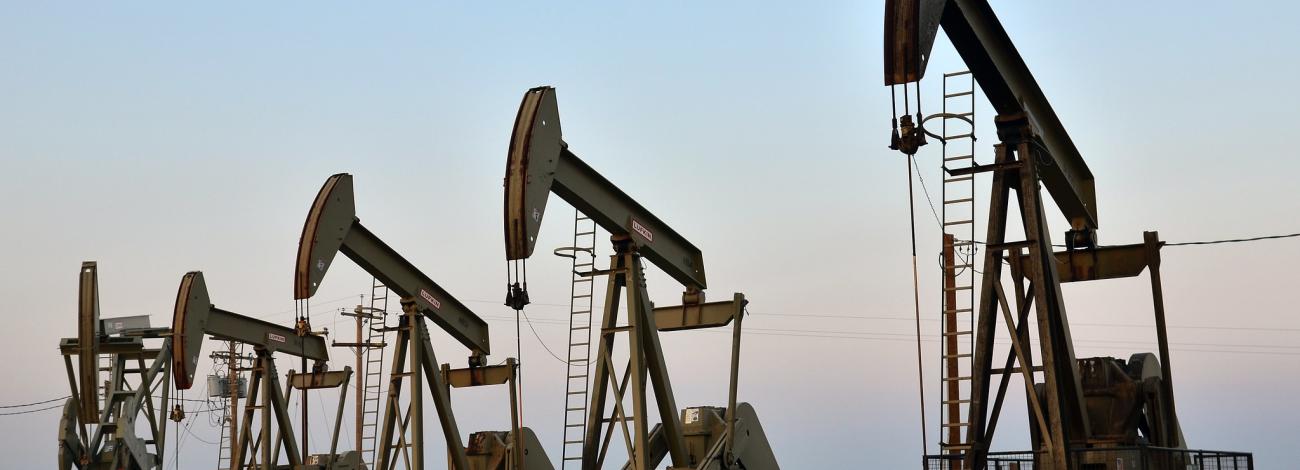 Five oil rigs on flat land. 