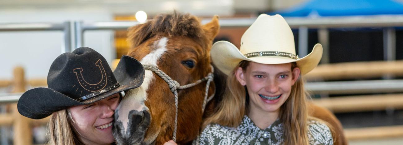 4-H youth smile as their young horse is adopted during the 2024 Idaho Horse Expo