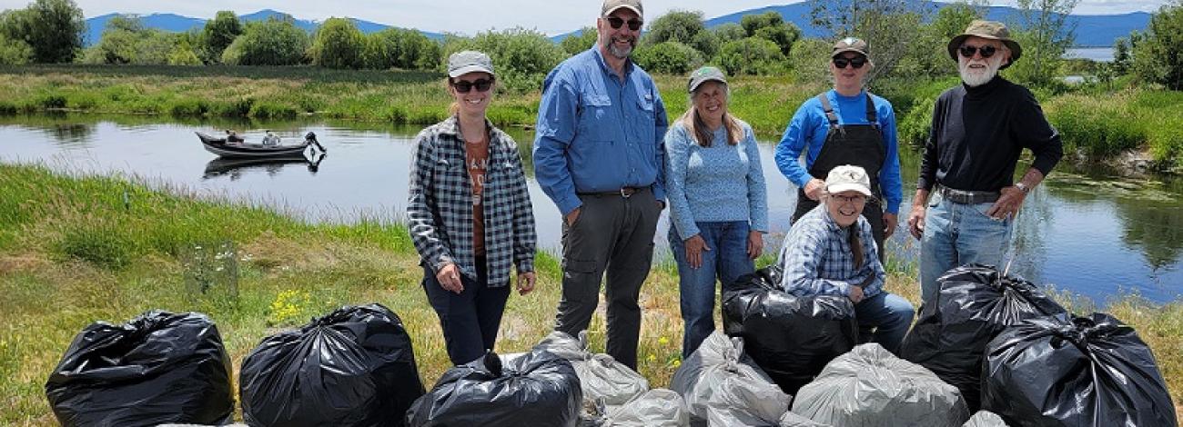 group of volunteers standing near bagged garbage at Wood River Wetlands