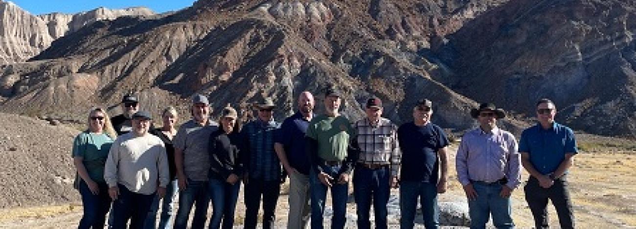 A line of DAC members stands in front of rocky, white desert hills.